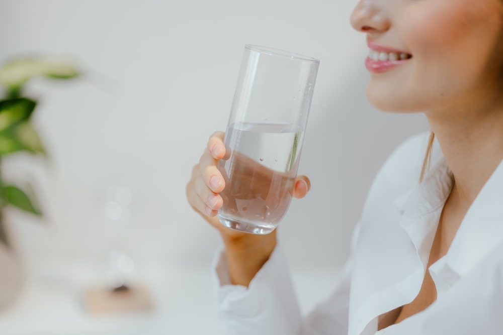 Gros plan d'une femme buvant de l'eau